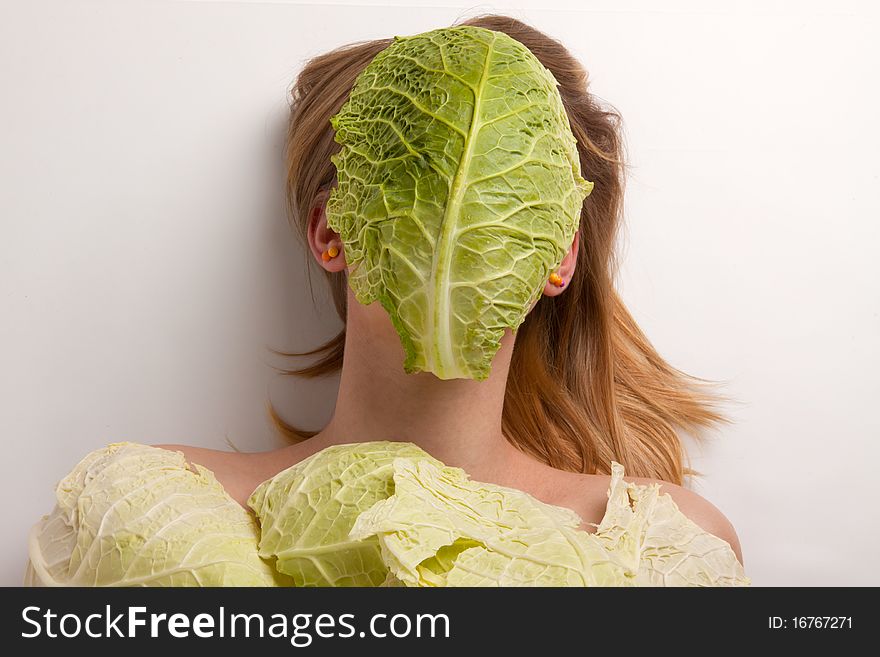 A young woman covered with collard greens. A young woman covered with collard greens
