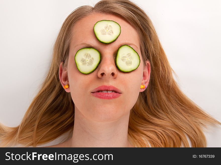 A young woman with a cucumber face mask