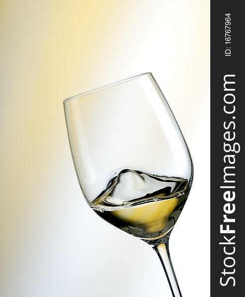 Glass of white wine and white with yellow background