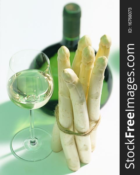 Glass and bottle of white wine with asparagus
