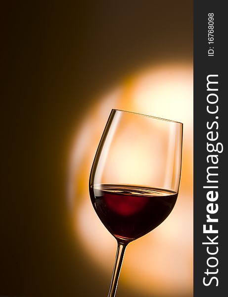 Glass of red wine in an orange spotlight