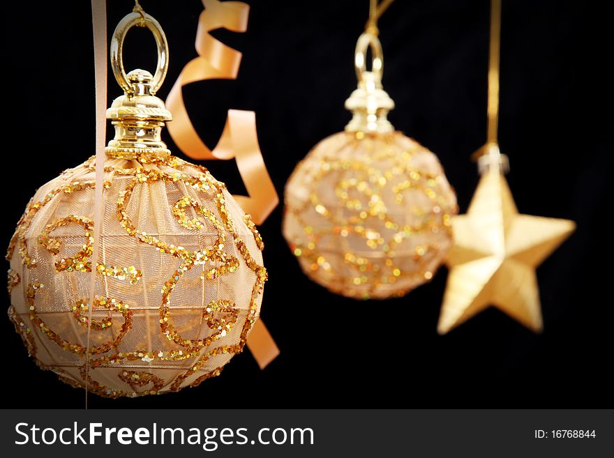 Golden Christmas balls and star on black background
