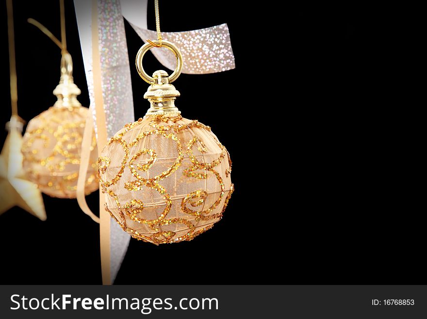 Golden christmas ball on black background, space to insert text or design
