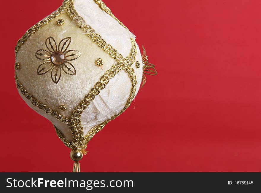 White and gold christmas ball on red background, space to add text or design