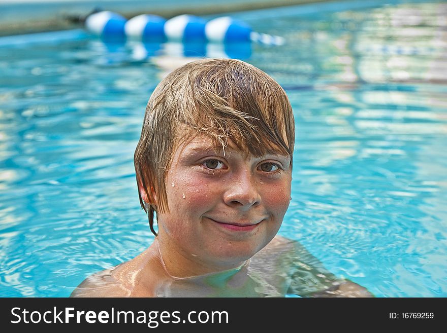 Boy enjoys swimming in an outdoor pool