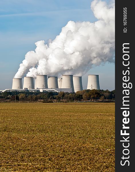 Cooling towers of a power plant with steam clouds and sky. Cooling towers of a power plant with steam clouds and sky