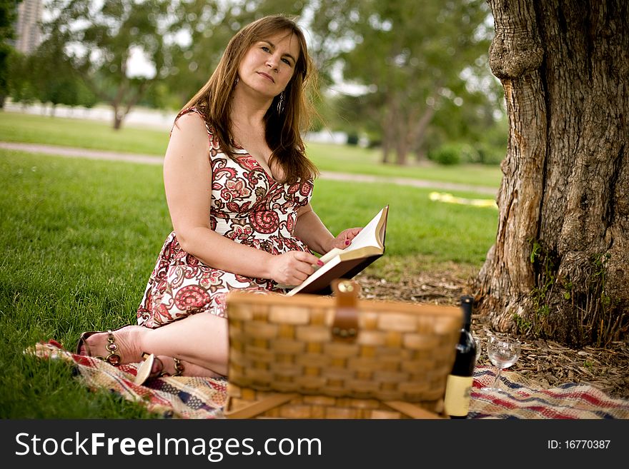 Woman having a picnic in a park in the summertime. Woman having a picnic in a park in the summertime