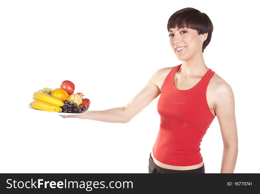 A woman holding out a plate of fresh fruit with a happy expression on her face. A woman holding out a plate of fresh fruit with a happy expression on her face.