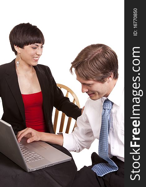 A business woman and man working on the computer laughing together.