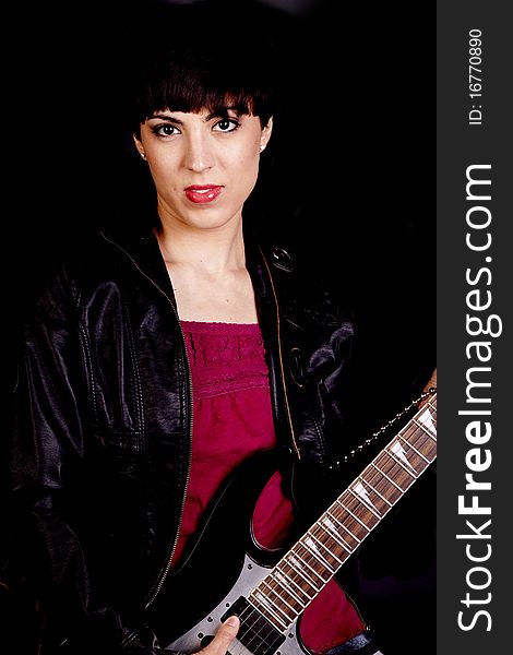 A woman with a expression on her face holding a guitar. A woman with a expression on her face holding a guitar.