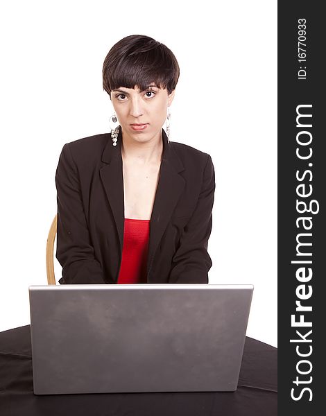 A business woman looking forward with a serious expression working on her computer. A business woman looking forward with a serious expression working on her computer.