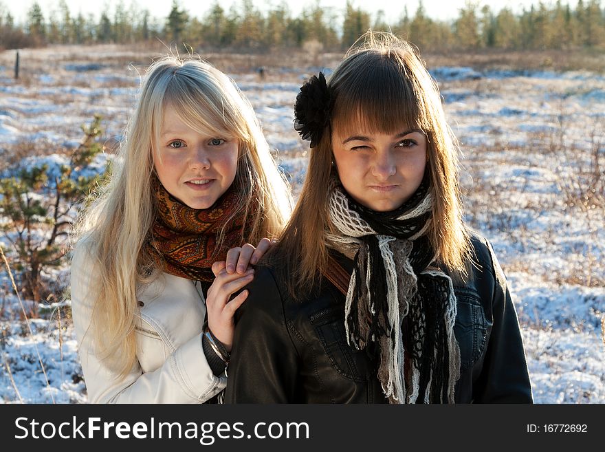 Two young beautiful girls on snow landscape