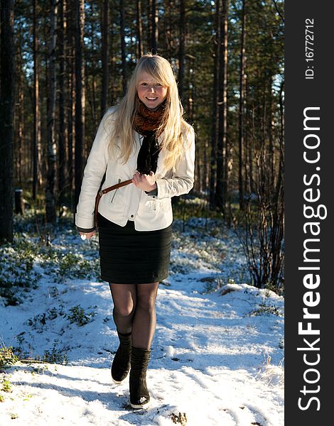 Young beautiful girl in white jacket on background wood