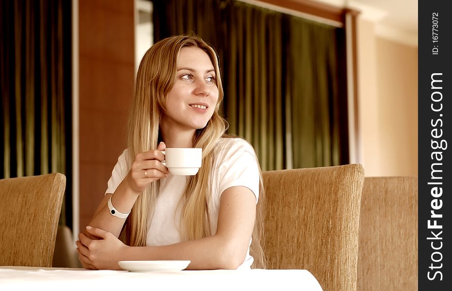 Happy woman in white with cup of coffee or tea. Happy woman in white with cup of coffee or tea.