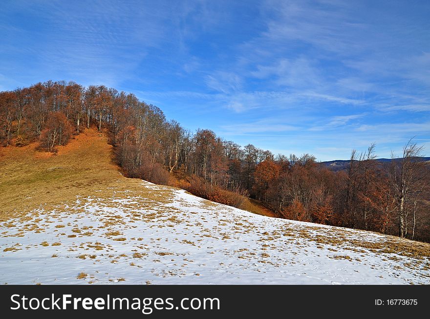 Autumn in mountains in a landscape under the dark blue sky with clouds. Autumn in mountains in a landscape under the dark blue sky with clouds.