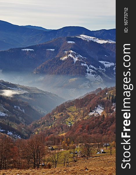 Autumn in mountains in a landscape under the dark blue sky with clouds. Autumn in mountains in a landscape under the dark blue sky with clouds.