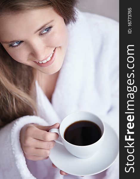 A young girl holding a cup of coffee close up. A young girl holding a cup of coffee close up
