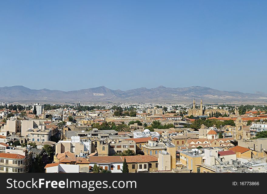 Northern Nicosia symbols: steeples of Selimiye mosque (ex. St. Sophia Cathedral) and huge flags on a hill. Northern Nicosia symbols: steeples of Selimiye mosque (ex. St. Sophia Cathedral) and huge flags on a hill