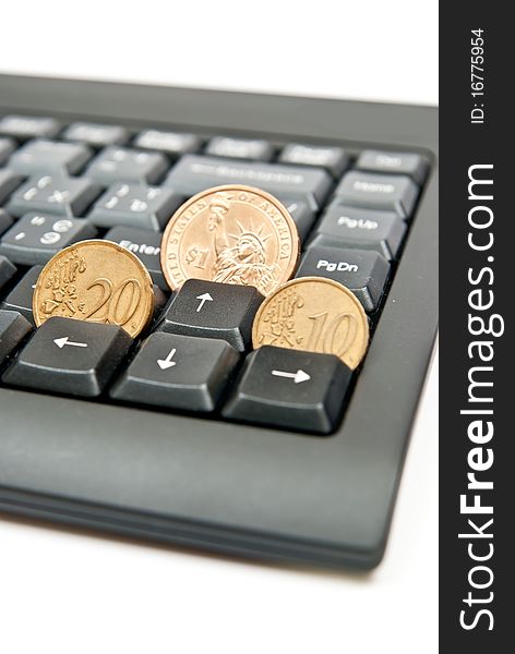 Three coins on a black computer keyboard. Three coins on a black computer keyboard