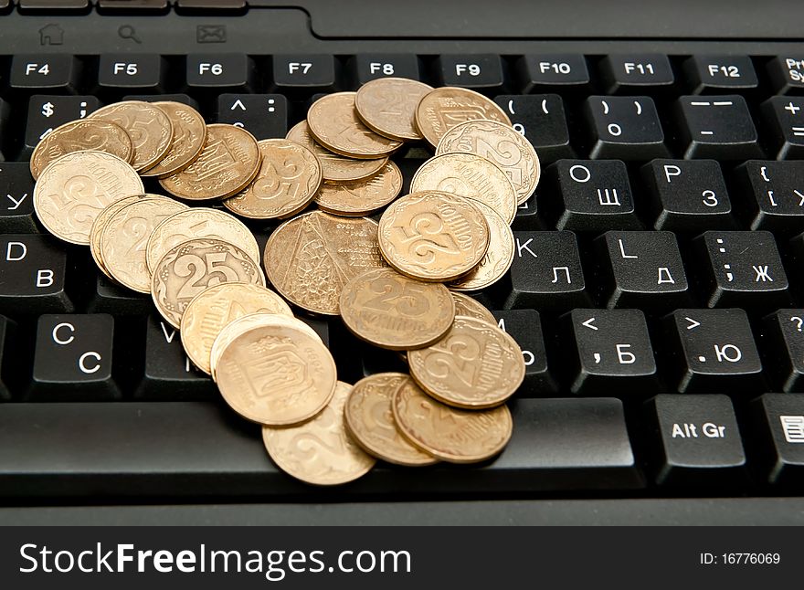 Heap of yellow coins on black keyboard. Heap of yellow coins on black keyboard