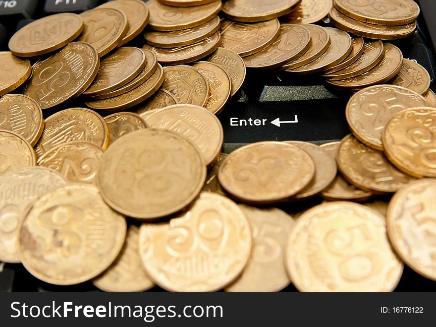 Heap of yellow coins on black keyboard. Heap of yellow coins on black keyboard