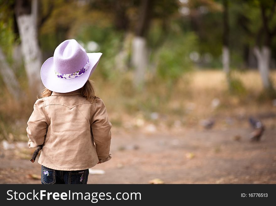 The little cowgirl walks in wood