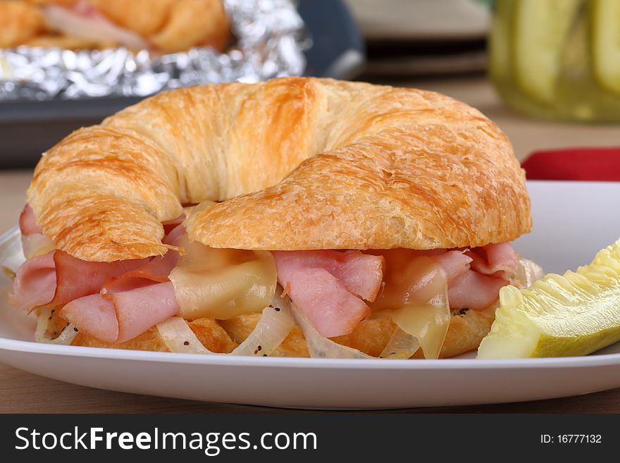 Ham and cheese with onions on a croissant bun. Ham and cheese with onions on a croissant bun