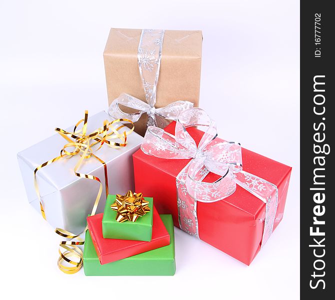 Gifts in silver, green, brown and red wrapping with bows on white background