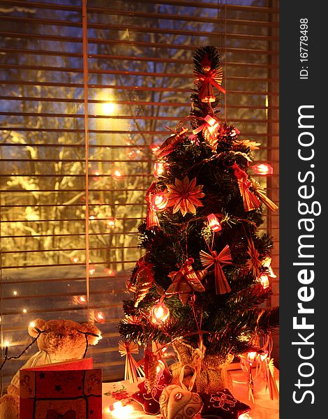 Christmas tree by the window with lights on