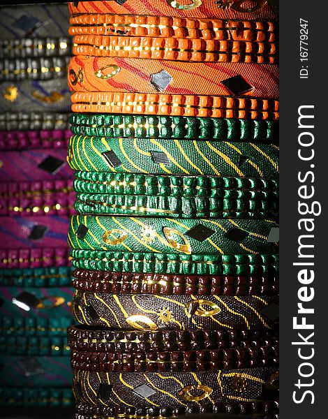 Background created from stacks of colorful Asian bangles with a dark tone. Background created from stacks of colorful Asian bangles with a dark tone.