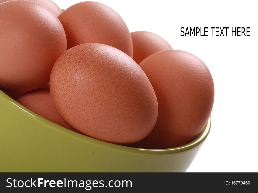 Fresh brown eggs in green bowl. Isolated over white