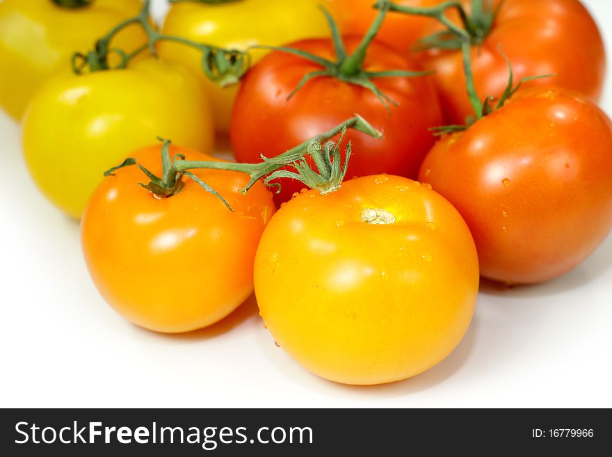 Many colorful fresh tomatoes on white background