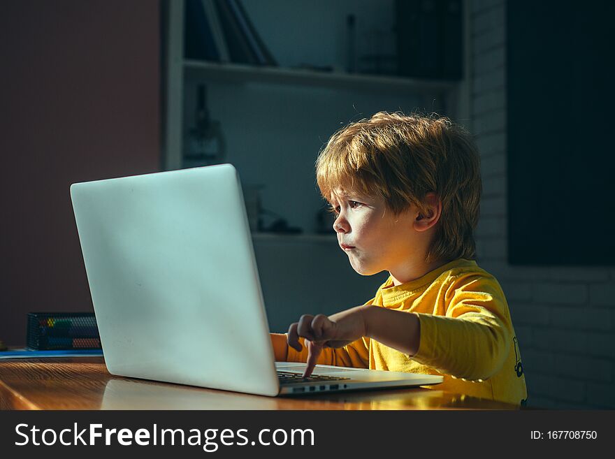 Little Boy Looks At A Laptop Screen Waiting For A Download. Search The Internet. New Information. Fast Internet