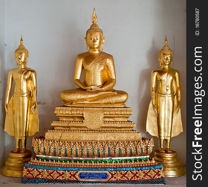 Three thai golden buddha image at white wall in temple