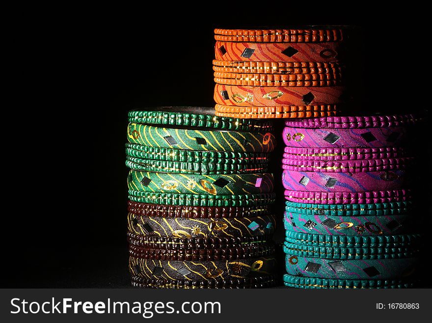 Background created from stacks of colorful Asian bangles with a dark tone. Background created from stacks of colorful Asian bangles with a dark tone.