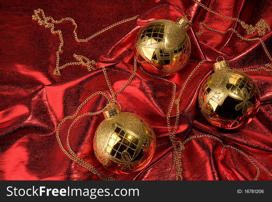 Shiny gold baubles with red background material. Shiny gold baubles with red background material