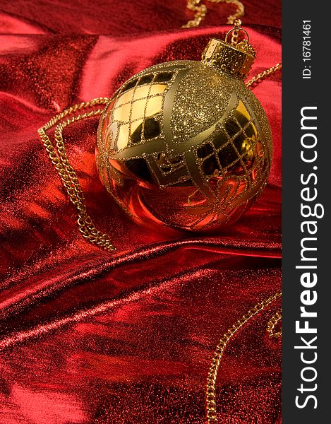 Shiny gold bauble with red background material. Shiny gold bauble with red background material