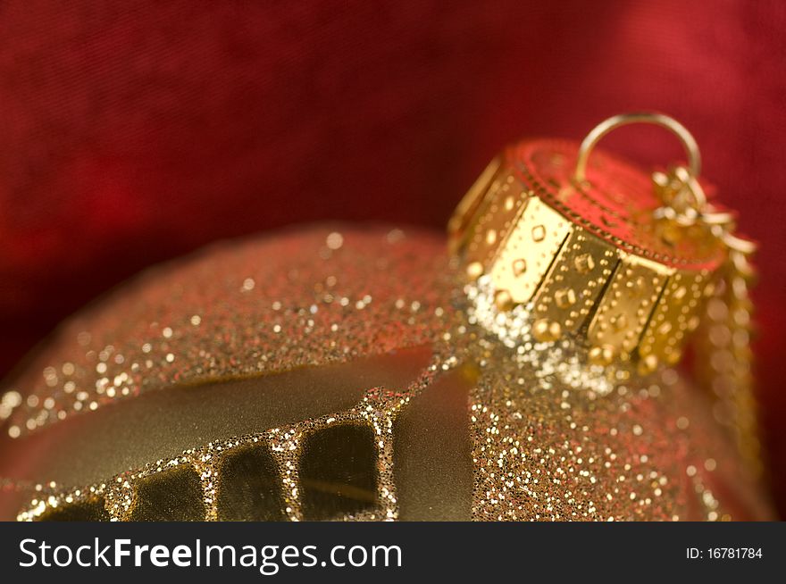 Shiny gold bauble with red background material. Shiny gold bauble with red background material