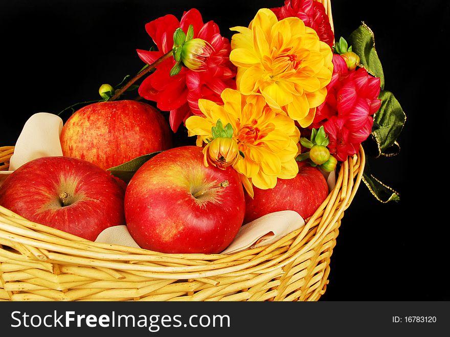 Autumn Basket with red apples and flowers isolated on the black background. Autumn Basket with red apples and flowers isolated on the black background.
