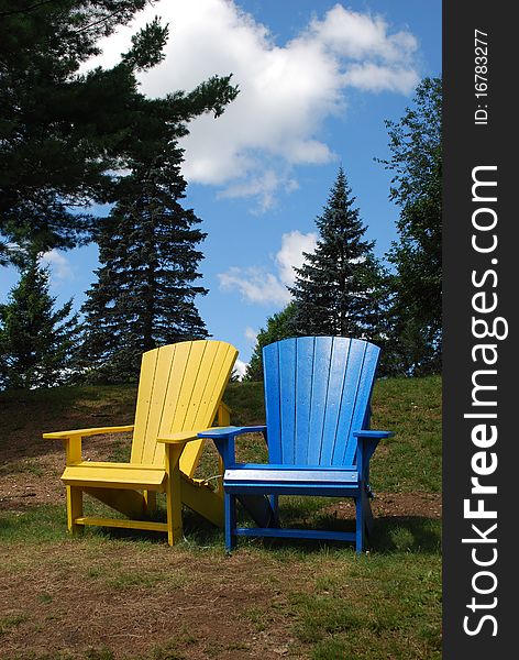 Two colorful chairs in a park, Algonquin Provincial Park, Ontario, Canada. Two colorful chairs in a park, Algonquin Provincial Park, Ontario, Canada