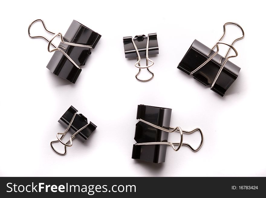 5 binder clips in in different positions and in different lighting with shadows on the white