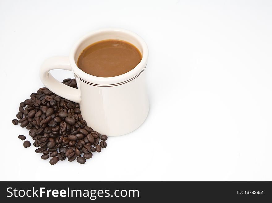 Cup of coffee next to pile of coffee beans