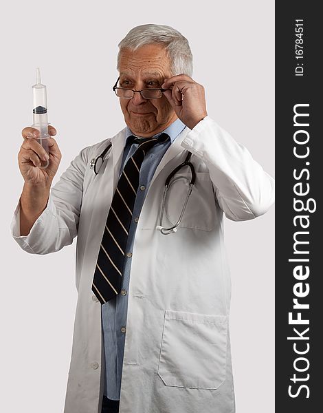 Elderly man doctor with grey hair and eyeglasses wearing white lab coat holding a syringe. Elderly man doctor with grey hair and eyeglasses wearing white lab coat holding a syringe
