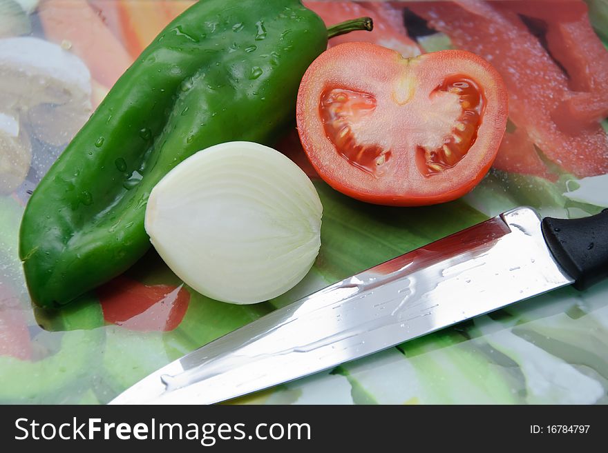 Fresh vegetables on a cut table. Tomato, onion and pepper