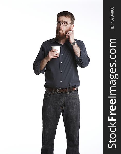 Man with beard in casual attire holding a paper coffee cup scratches his beard and makes a funny face. Man with beard in casual attire holding a paper coffee cup scratches his beard and makes a funny face