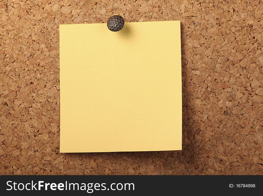Blank Yellow textured notebook paper Pinned to the cork board. Blank Yellow textured notebook paper Pinned to the cork board.