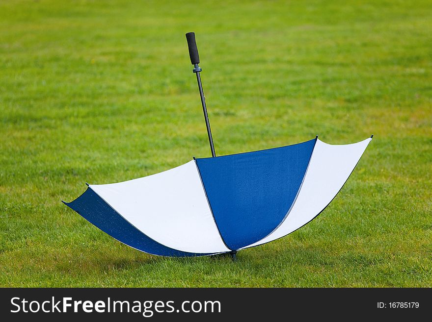 Umbrella turned by a wind on green field