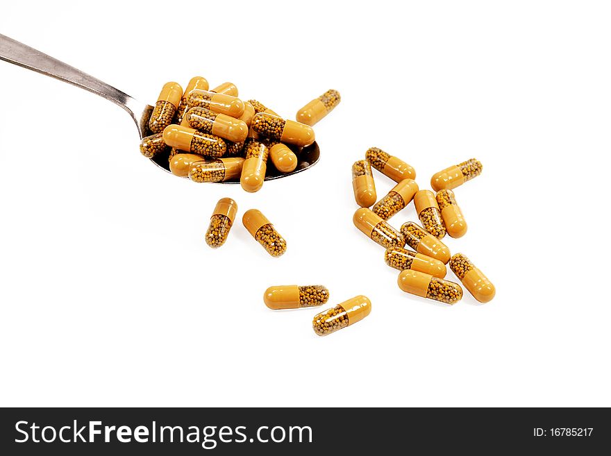 Supplements in spoon isolated on white background