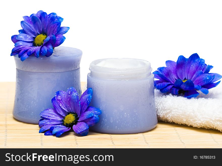 Spa essentials, cream and towel with blue flowers