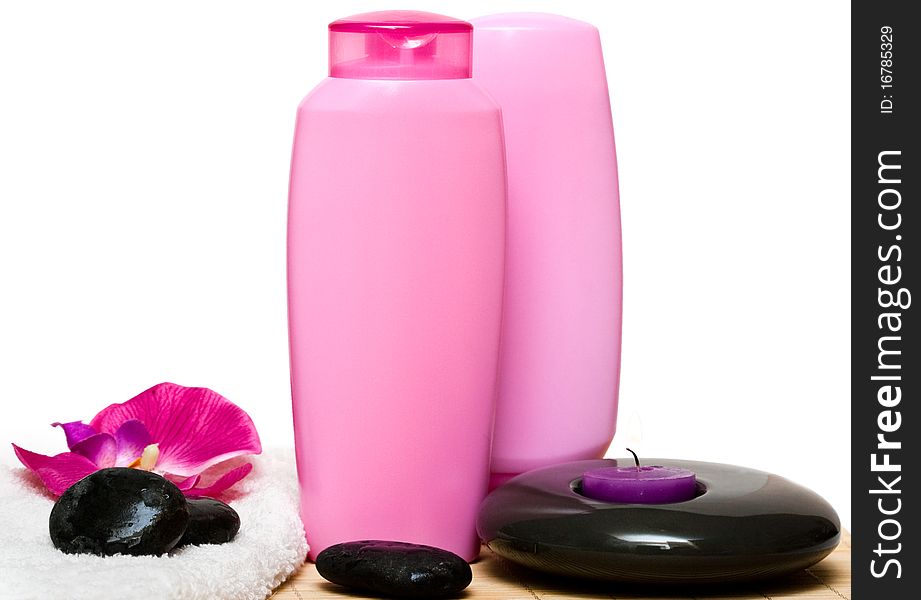 Candle, bottle of shampoo with stone and orchid